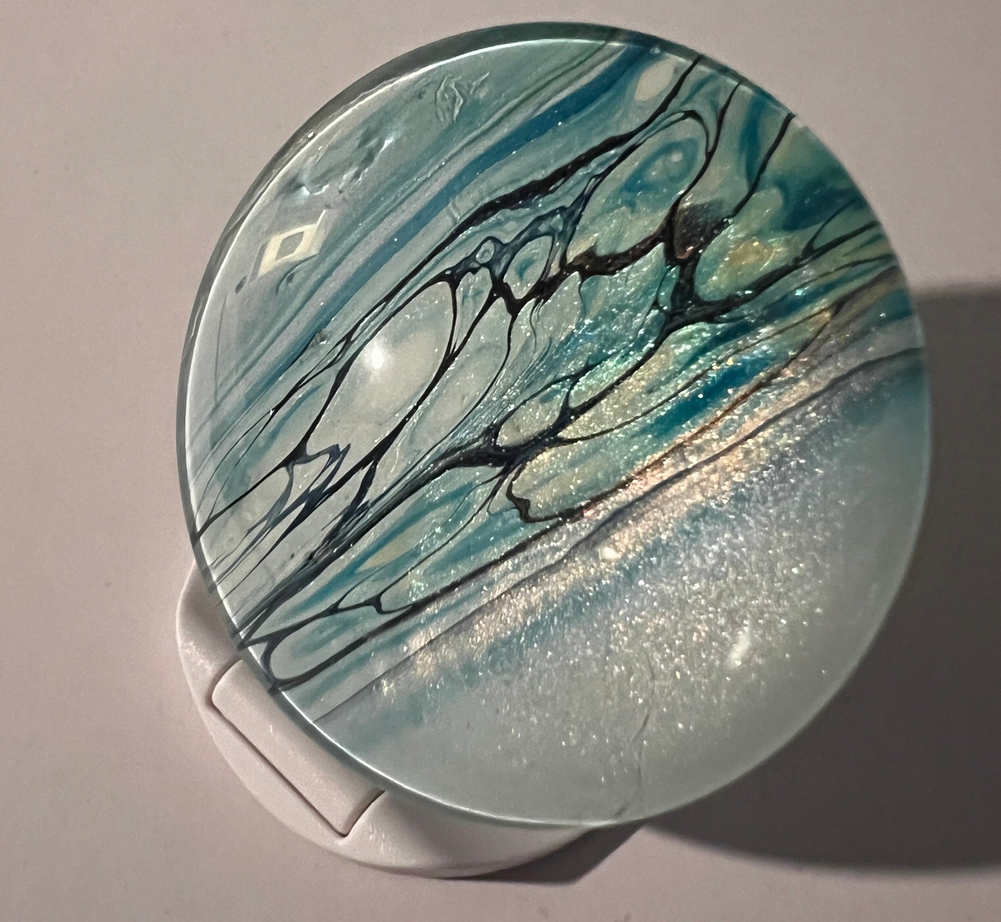 shiny popsocket phone grip in teals and blues.