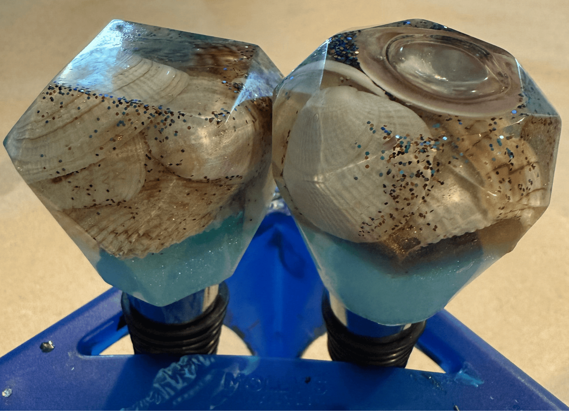 Geometric-shaped bottle stoppers made with resin filled with real shells