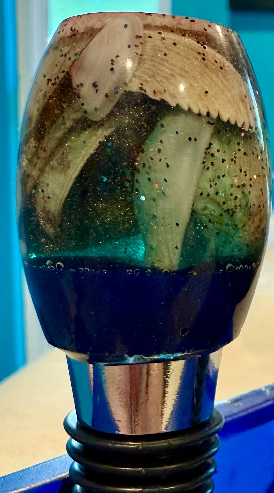 Oblong topped bottle stopper made with resin filled with real shells