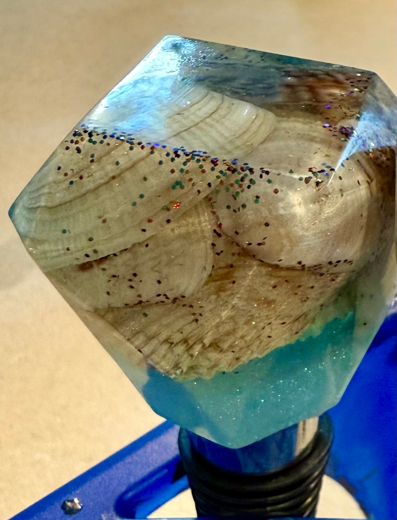 Geometric shaped bottle stopper made with resin filled with real shells