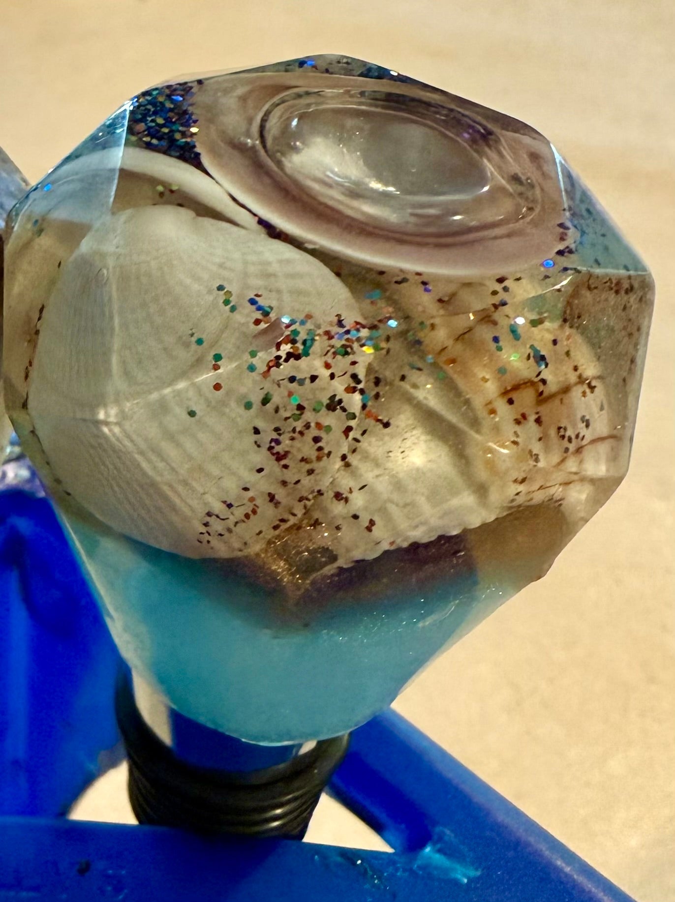 Geometric-shaped bottle stopper made with resin filled with real shells